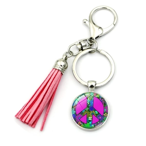 Detailed view of pink tassel keychain featuring a peace sign glass pendant and silver clasp