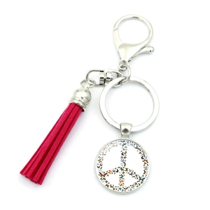 Close-up of peace sign keychain with colorful butterflies and bright pink tassel detail