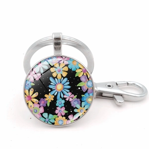 Detailed view of hippie flower keychain with watercolor glass cabochon and lobster clasp