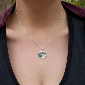 Luminous moon pendant necklace with glowing silver chain worn by a female model