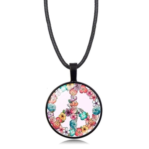 Macro detail of round glass pendant with floral peace sign on black leather cord