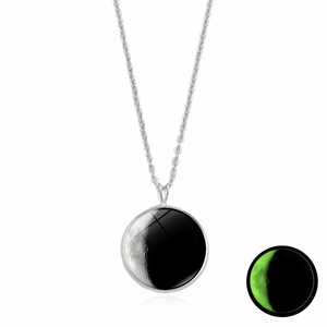 Detailed view of silver moon necklace with glowing green moonstone effect in dark