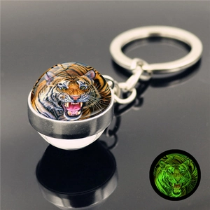 Luminous tiger head crystal glass keychain showing glowing green fluorescent effect