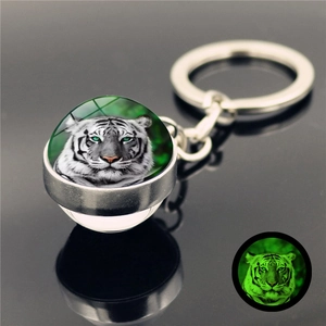 Luminous crystal glass ball keychain with tiger head design showing green glow effect