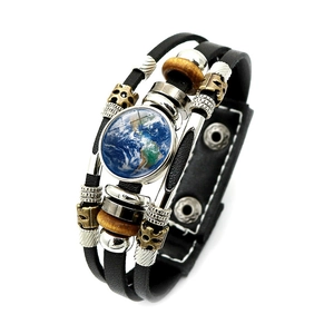 Dettaglio del bracciale multistrato in pelle con cupola in vetro terra e perline