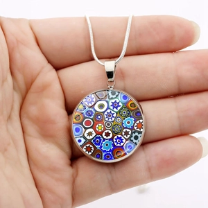 Dettaglio del ciondolo in vetro Millefiori con motivi floreali colorati e cornice d'argento