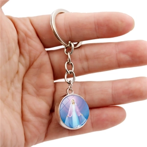 Detail of silver metal keychain with a Virgin Mary religious glass dome pendant charm