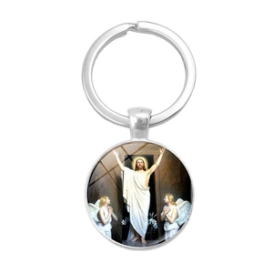 Gros plan d'un porte-clés en argent avec cabochon en verre et peinture religieuse de Jésus