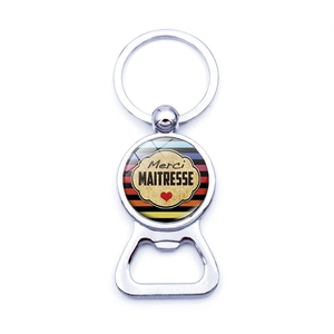 Close-up of silver metal beer bottle opener keychain with Merci Maitresse teacher gift design