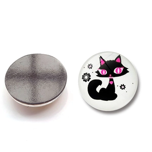 Detail of round magnetic fridge sticker with cute black cat illustration and magnetic back