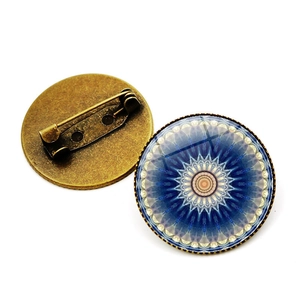 Detalle de broche de mandala en vidrio y bronce con vista de la estructura del alfiler