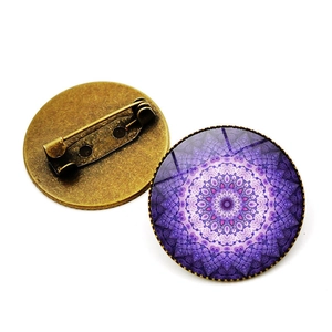Vista detallada frontal y trasera de un broche de vidrio mandala vintage con base bronce