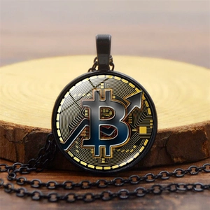Detalle macro del colgante Bitcoin negro con diseño de circuito sobre rodaja de madera