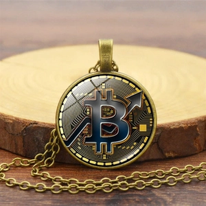 Detalle del collar de Bitcoin vintage en bronce con colgante de vidrio sobre fondo madera