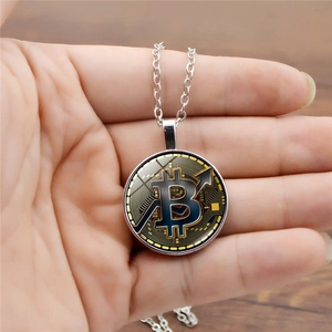 Collar con colgante de Bitcoin plateado con cabujón de cristal sobre fondo de madera