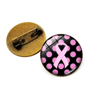 Détail du badge ruban rose avec dôme en verre et épingle en métal bronze rétro
