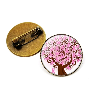 Vue détaillée de la broche arbre de vie avec rubans roses et base en bronze antique