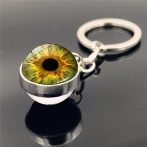 Macro detail of realistic yellow-green evil eye iris on double-sided crystal glass keychain