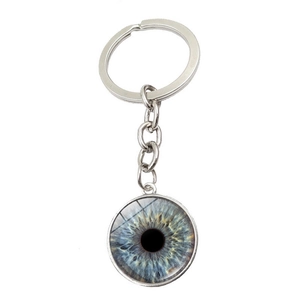 Détail macro d'un porte-clés en métal argenté avec motif d'iris bleu et gris