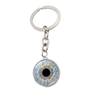 Détail macro d'un pendentif en verre iris bleu réaliste sur un porte-clés en métal argenté