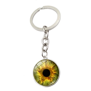 Détail du porte-clés œil iris jaune-vert avec anneau en métal argenté poli sur fond blanc
