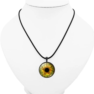 Detail view of eye pendant necklace with green cat eye iris on a white mannequin