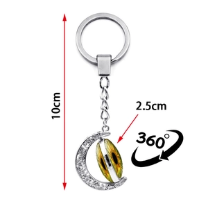 Detailed view of silver moon keychain with rotating evil eye pendant and 10cm size marking