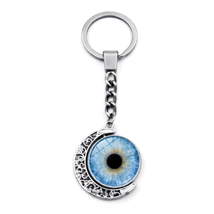 Detail of rotating crescent moon keychain with a blue evil eye glass pendant on silver link