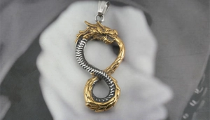 Macro detail of two-tone dragon infinity pendant with intricate scale textures