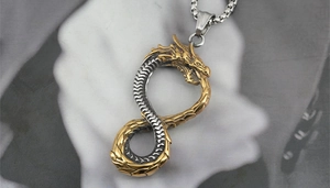 Macro shot of double-tone dragon pendant on box chain with intricate scale textures