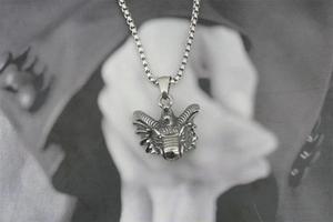 Detailed close-up of a dragon head pendant with box chain in retro punk style