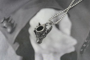 Macro shot of vintage dragon head pendant with detailed scales and box chain necklace