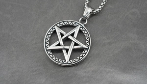 Détail du pendentif pentagramme style Viking avec chaîne box sur fond de tissu foncé