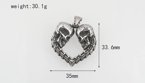 Vue détaillée du pendentif crâne en forme de cœur en acier titane argenté vieilli