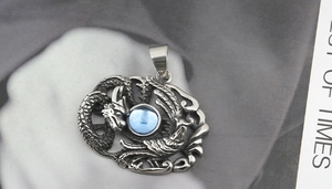 Détail du pendentif dragon et phénix avec pierre bleue sur acier inoxydable vintage