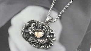 Vue détaillée du pendentif dragon et phénix sur chaîne en argent vieilli vintage