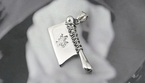 Détail macro d'un pendentif en acier en forme de couteau de cuisine au style punk rock