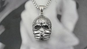 Makroansicht von Vintage-Totenkopf-Anhänger mit Boxkette und Distressed-Metallstruktur