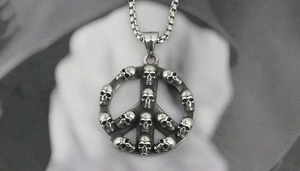 Detailed macro view of vintage silver peace sign pendant with skull textures and box chain