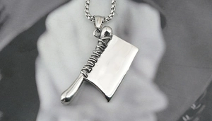 Détail d'un pendentif hachoir créatif en argent avec textures vintage et chaîne gourmette