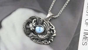 Détail du pendentif dragon vintage avec gemme bleue et collier à chaîne maille boîte