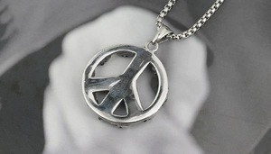 Macro shot of a vintage silver peace sign pendant with a sturdy metal box chain