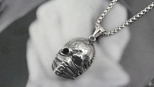 Nahaufnahme des Vintage Punk Totenkopf Maskenanhängers in Antik-Silber mit runder Boxkette