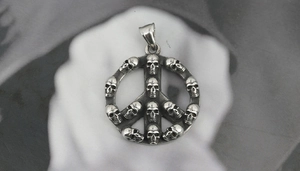 Detailed macro view of vintage titanium steel skull peace sign pendant with aged silver finish