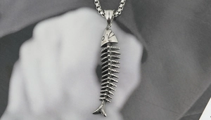 Detailed close-up of a retro silver fish bone skeleton pendant in stainless steel