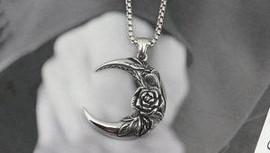 Macro shot of retro titanium steel moon and rose pendant with vintage embossed texture