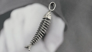 Macro shot of retro S925 silver fishbone pendant with vintage texture and engraved details