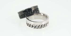 Vista macro de anillos de acero de titanio con cadena giratoria y números romanos