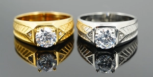 Detail of silver and gold rings with round center stones and engraved band textures