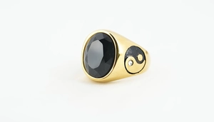 Macro detail of vintage gold ring featuring black gemstone and yin-yang side symbol